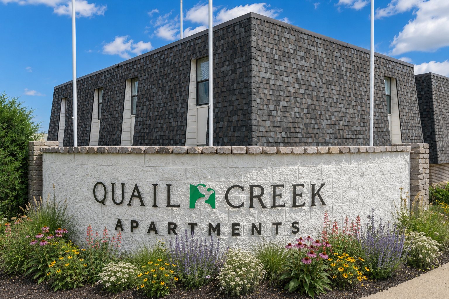 Quail Creek Apartments entrance sign with landscaping